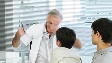 senior doctor attending to a child in his office