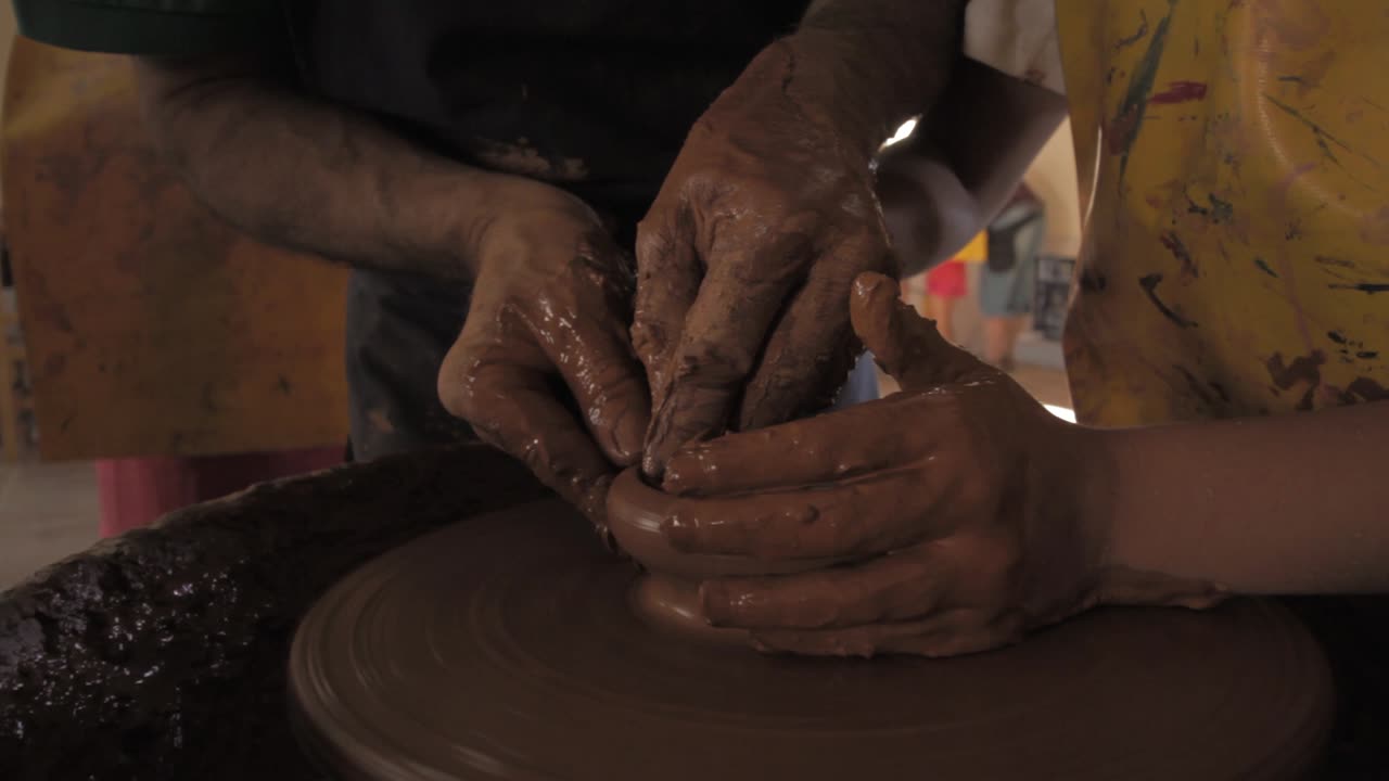 Pottery workshop, Close up of hands clay throwing on pottery wheel, teacher with kid