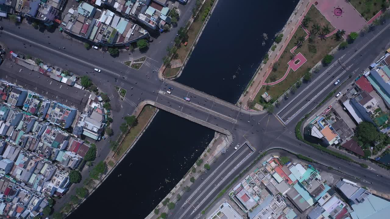 베트남 호치민시의 교통 교량과 고가도로, 운하, 옥상, 공원 및 도로 교통을 특징으로 하는 화창한 날 하향식 공중 회전 전망