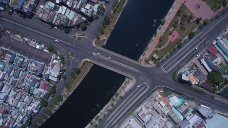 puente de tráfico y paso elevado en la ciudad de ho chi minh, vietnam, vista de rotación aérea de arriba hacia abajo en un día soleado con el canal, los tejados, el parque y el tráfico rodado