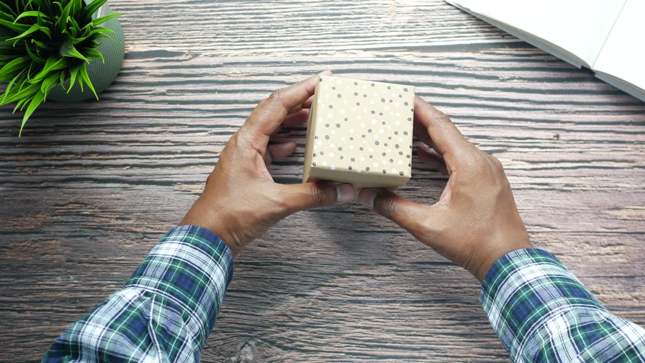 선물 상자를 들고 열고 있는 사람