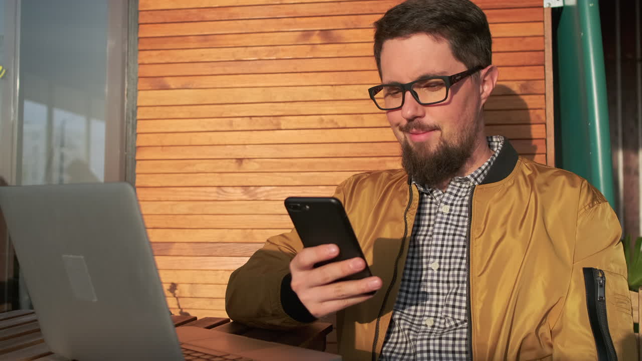 hombre trabajando al aire libre en portátil y teléfono