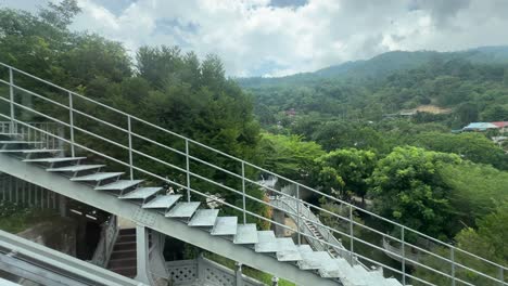 skylift is elevating up and against the scenic background view of the green hill