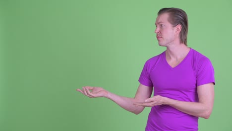 fotografía de estudio de un joven triste mostrando el espacio de copia contra un fondo verde