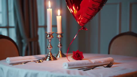 romantic dinner setting with red balloon and candles