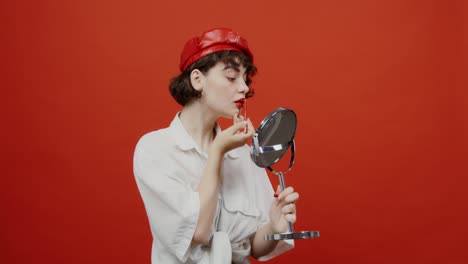 mujer aplicando lápiz labial frente al espejo