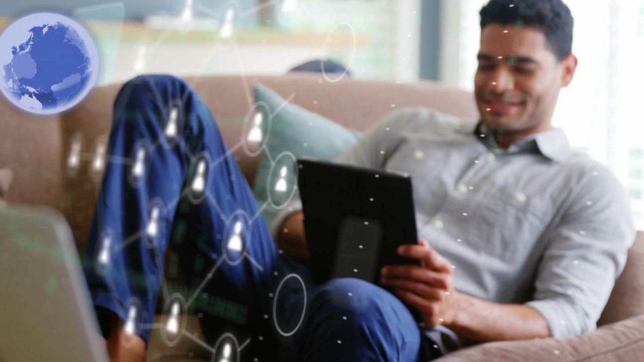 Man tapping tablet on couch activating AR phone panel above laptop aligning user nodes viewing net