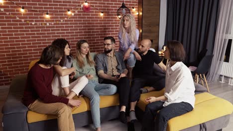 Guys-and-smiling-girls-talking-and-discussing-at-home