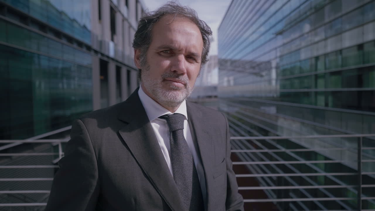 Successful mature businessman in suit posing with crossed arms