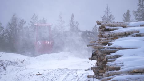 Birch-log-Pile-on-timber-industrial-site-snow-capped-under-Snowfall---Wide-Static-shot