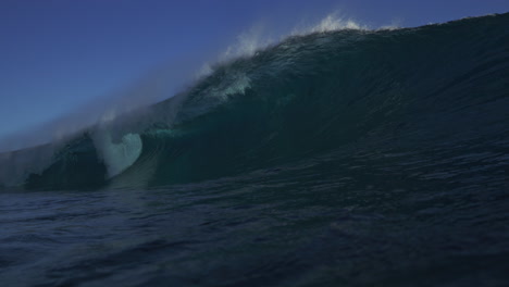 vista desde la superficie del agua del océano como una fuerte ola se rompe en un fuerte barril