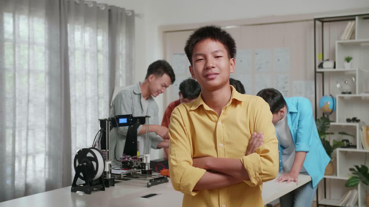 3d 프린팅과 노트북으로 집에서 일하는 젊은 아시아 소년들의 그룹, 소년은 웃으며 친구들이 일에 대해 논의하는 동안 카메라에 팔을 고 있습니다.