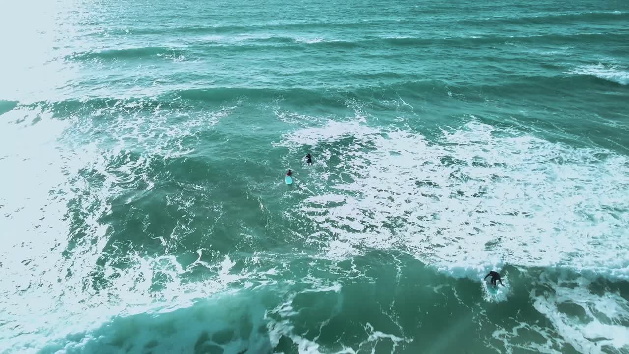 surfista principiante atrapando una pequeña ola. amplio disparo con dron