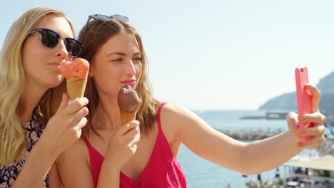 imágenes de video en 4k de dos mujeres jóvenes comiendo helado y tomando selfies en un día de verano a lo largo de la costa italiana