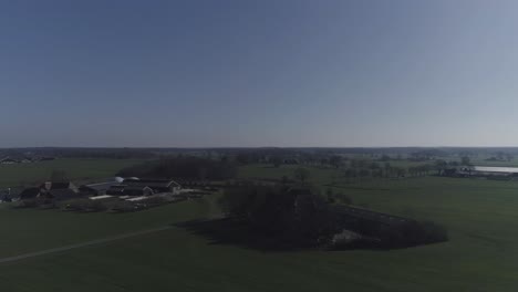 Drone-shot-turning-on-horizon-of-agriculture-landscape-and-town