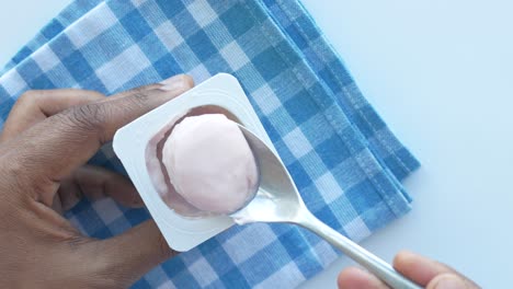 comiendo yogur de un recipiente