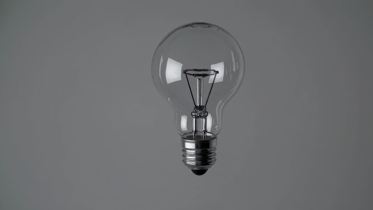 Video minimalista di una lampadina, ripreso da un angolo laterale su uno sfondo grigio semplice
