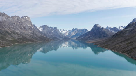 Atemberaubender-Blick-Auf-Den-Friedlichen-Bergsee-Mit-Glatter-Oberfläche,-Die-Die-Umliegenden-Gipfel-Und-Den-Himmel-Widerspiegelt