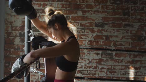 video of fit and tired caucasian woman resting after box training at gym