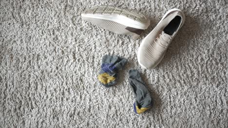 beige sneakers and socks on a gray carpet