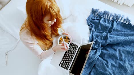 vista de ángulo alto de una mujer usando una computadora portátil mientras desayuna 4k