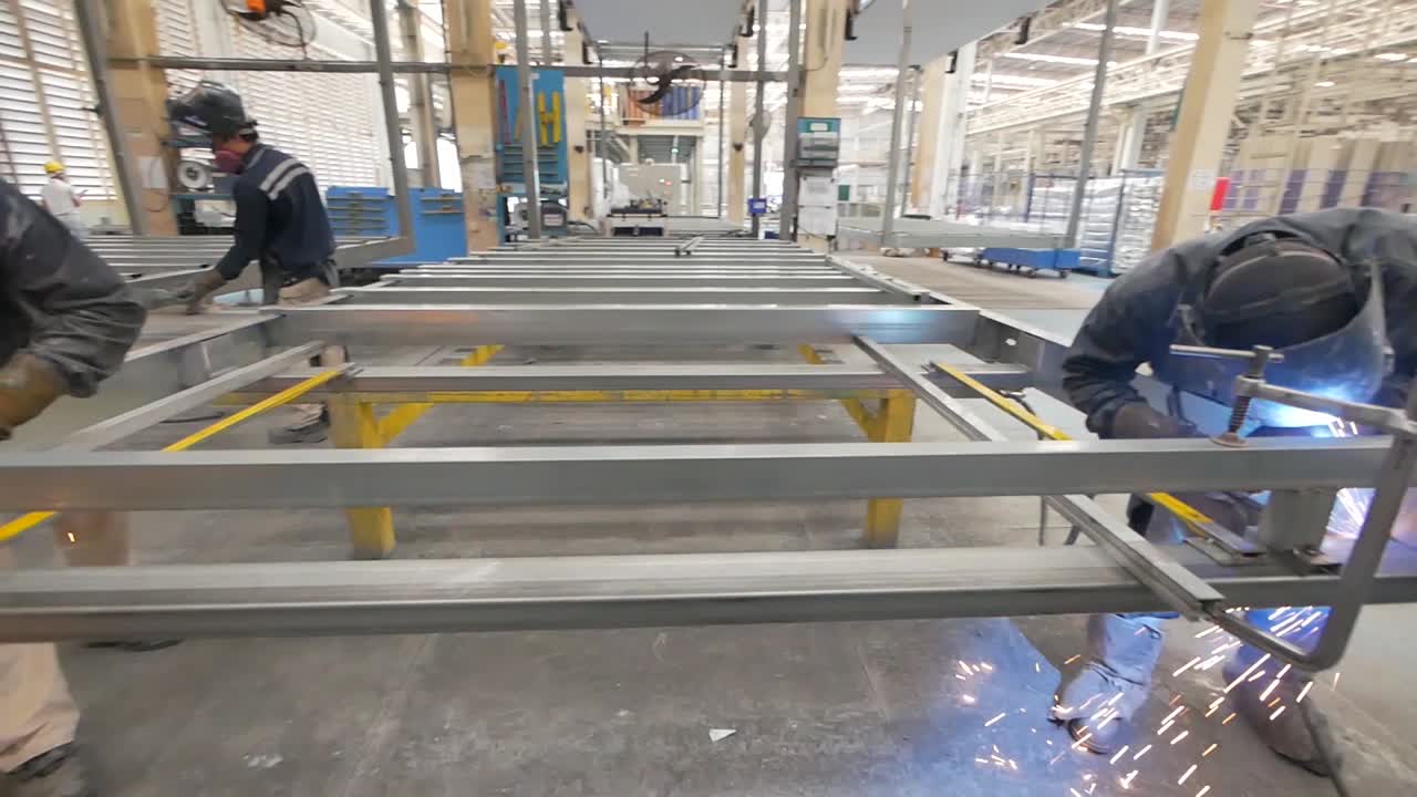 Workers Welding Metal Frames in a Factory