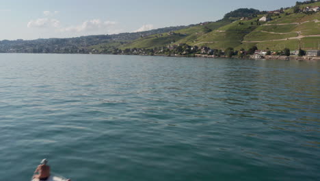 drone flying past small motorboat with a family on board driving over beautiful blue lake