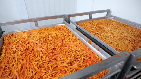 Large-pans-full-of-pasta-in-commercial-kitchen-on-food-trolley