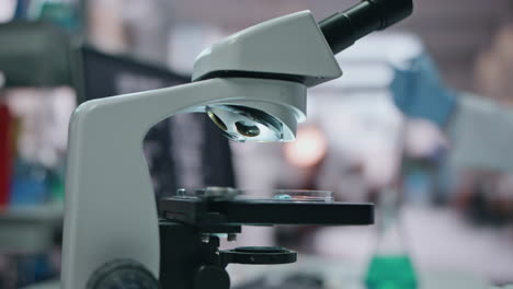 el médico pone a mano la muestra al microscopio usando una pipeta médica en el laboratorio de cerca.
