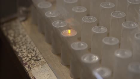 Primer-Plano-De-Velas-Votivas-Eléctricas-En-Una-Caja-Transparente-En-El-Santuario-De-Bom-Jesus-Do-Monte-En-Braga,-Portugal,-Enfatizando-La-Modernidad-En-Las-Prácticas-Tradicionales-De-Oración