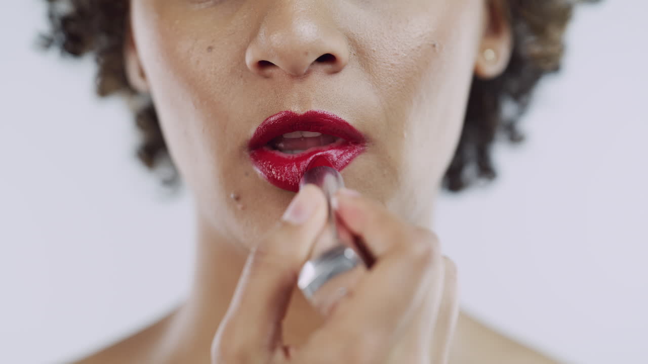 mujer aplicar lápiz labial rojo