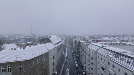 Erhöhte-Aufnahmen-Von-Gebäuden-Entlang-Der-Straße-In-Einem-Städtischen-Viertel.-Winter-In-Der-Stadt,-Schneefall,-Der-Die-Sicht-Einschränkt.-Berlin,-Deutschland