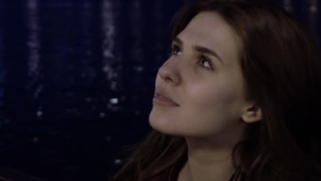 mujer mirando a una fuente por la noche