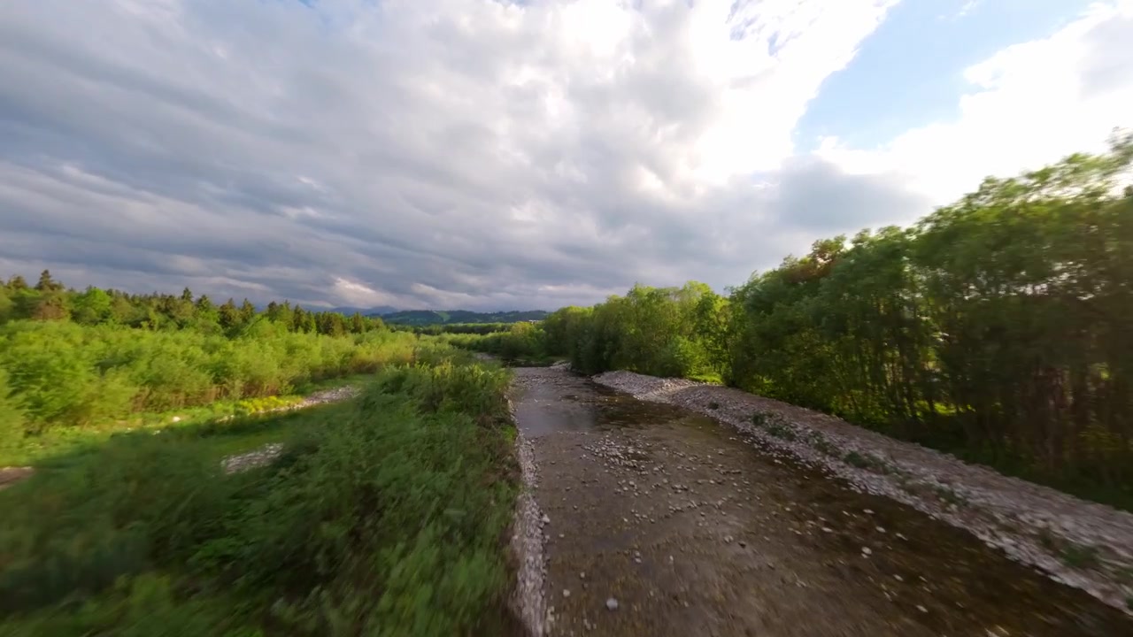 Cinematic aerial footage showcasing the beautiful Biaka Tatrzaska river winding through a vibrant green landscape under a cloudy sky.