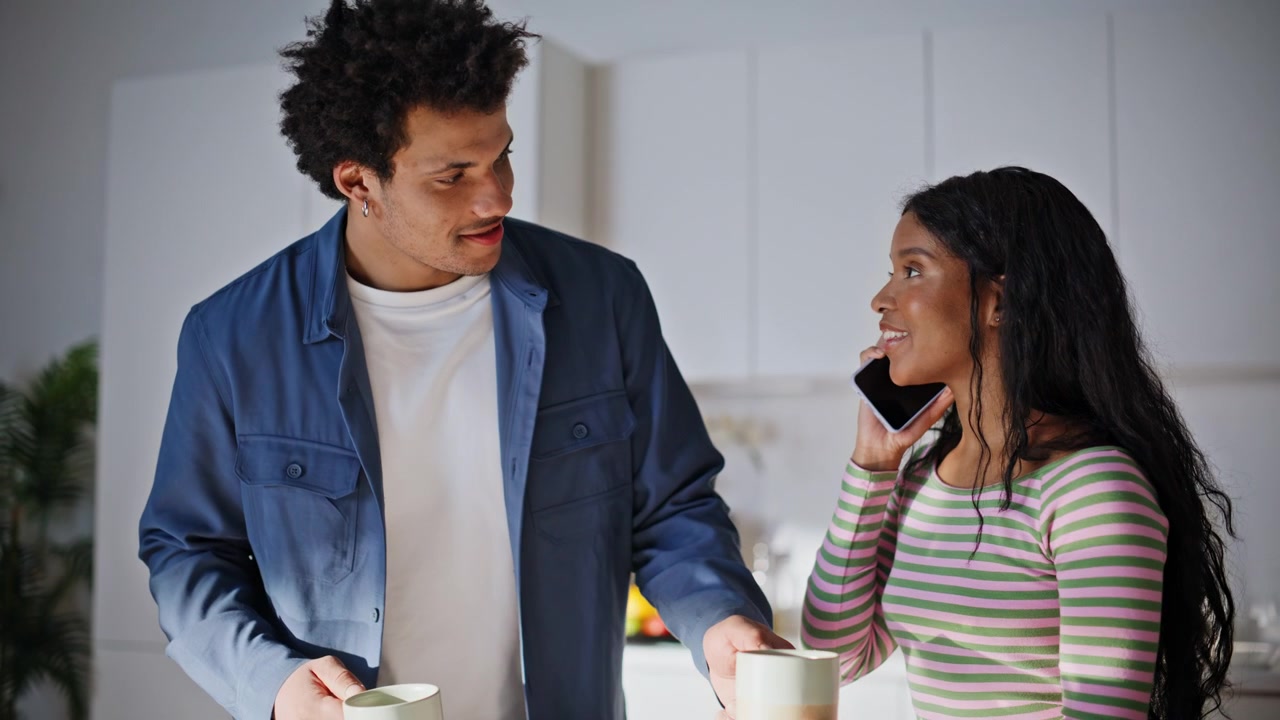 Smiling woman talking smartphone at kitchen closeup. Boyfriend bringing coffee