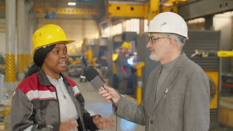 female factory worker giving interview to tv reporter