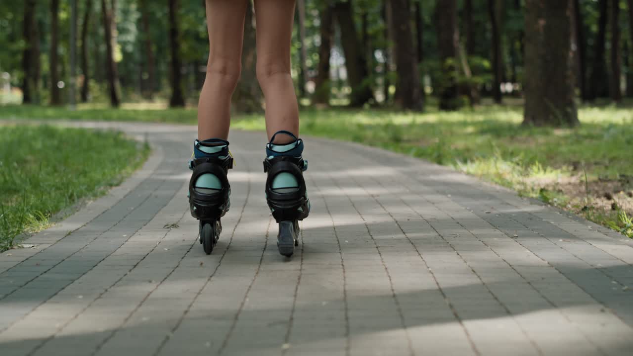Low section of girl skating at the park in summer day.