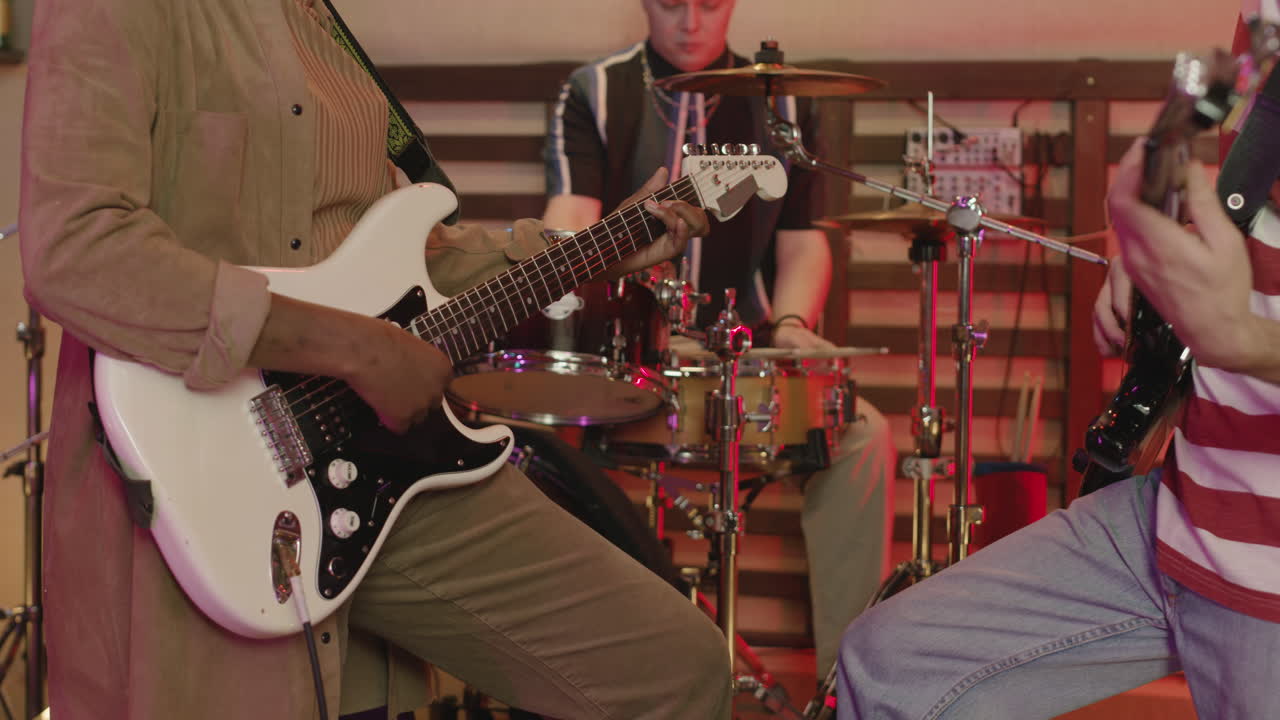 녹음실에서 리허설을 하는 알아볼 수 없는 다민족 음악 밴드를 닫습니다