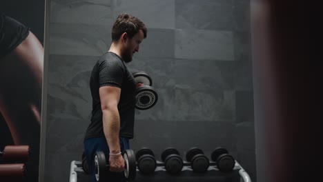 Atleta-De-Levantamiento-De-Pesas-Hace-Flexiones-De-Bíceps-Con-Mancuernas-De-Pie-En-El-Gimnasio-Interior