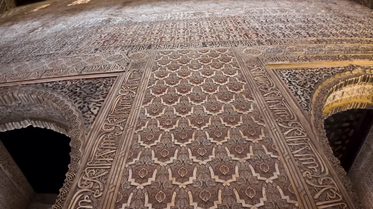 Upward detail shot of the arabesque decoration inside the Hall of the Ambassadors in the Nasrid Palaces of the monumental Alhambra complex in Granada, Spain