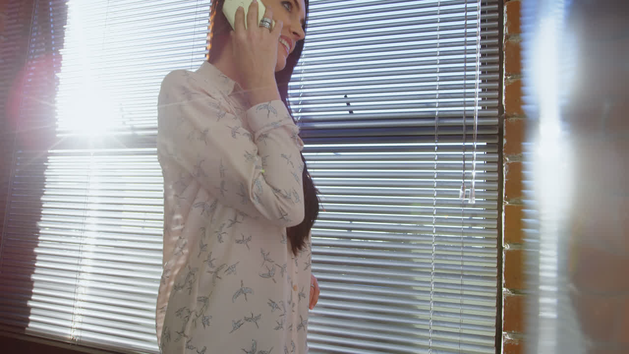 ejecutiva hablando por teléfono móvil en la oficina 4k