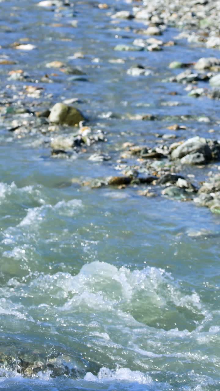 Un fiume tranquillo scorre sulle rocce a Glenorchy, Nuova Zelanda, sotto una luminosa luce naturale, cogliendo l'essenza della calma della natura