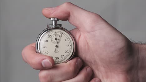 stopwatch in male hand counts down seconds