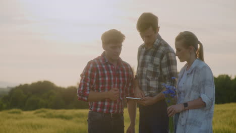 farmers discuss agricultural work using digital tablet at sunset