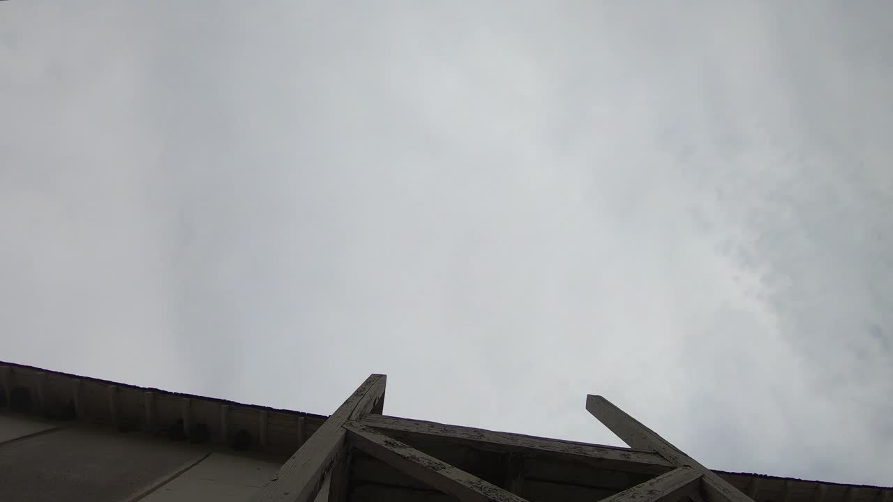 타임랩스 - 흐린 날 건물 앞의 구름을 똑바로 쳐다보다