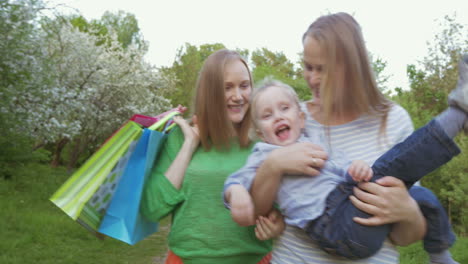 dos mujeres con un niño caminando en el parque verde
