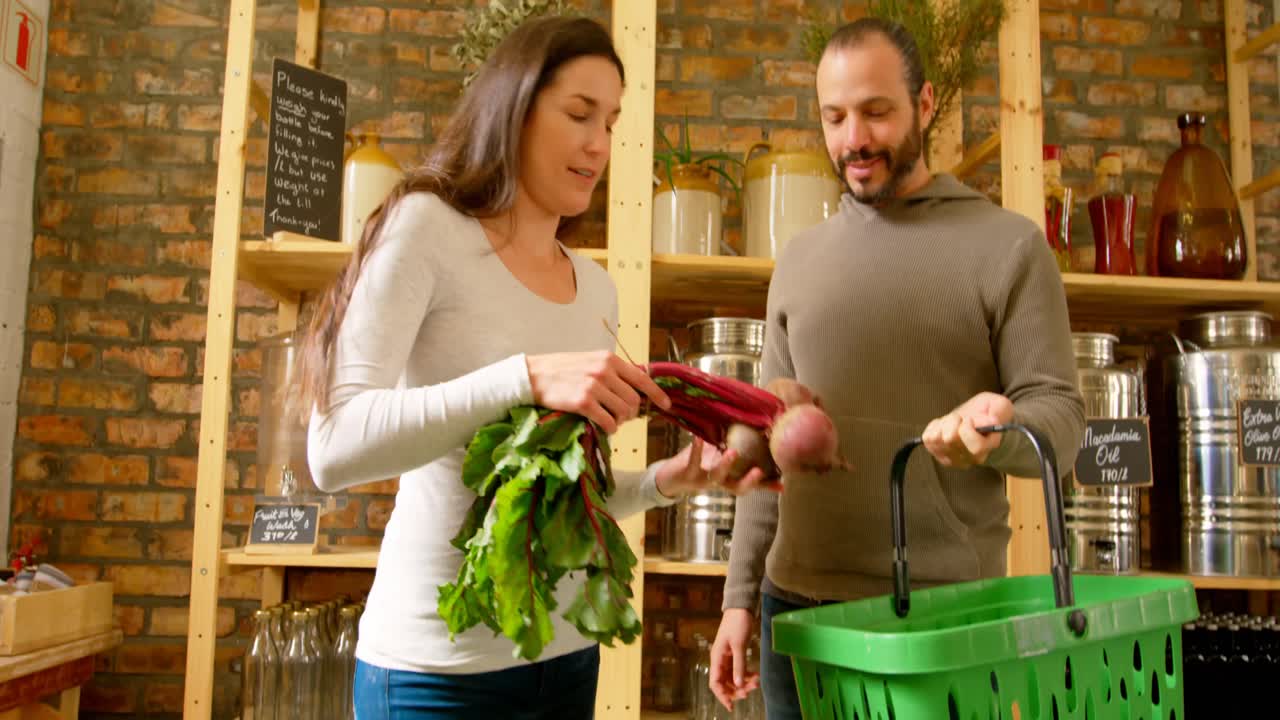 una joven pareja de compras en el supermercado 4k