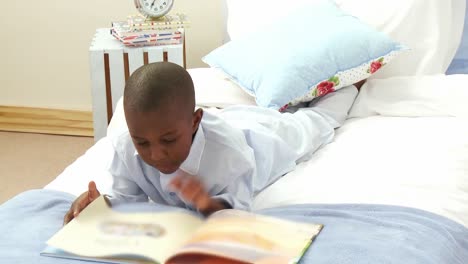 AfroAmerican-smiling-little-boy-reading-in-bed