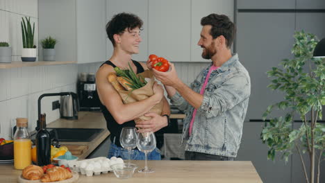 happy gay couple shopping and preparing food in kitchen
