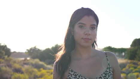 a beautiful hispanic woman modeling and posing with staring eyes outdoors in a desert nature landscape